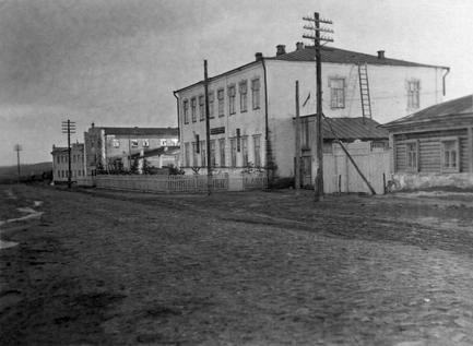 Павловка, улица Калинина. На переднем плане здание райкома КПСС и райисполкома. За ним находится церковно-приходская школа (на снимке не видна). Тут же виднеется памятник павшим в Гражданскую войну. Следующее здание со звездой наверху — клуб, построенный на месте Воскресенского храма, перед ним — место, где расстреляли о. Владимира Пиксанова. Лето 1948 г. Фото П. Балдуева. Из архива Р. В. Балджи (Харитоновой)